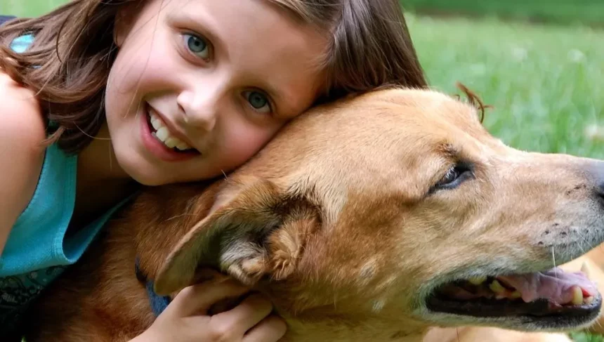 Garota abraçando cachorro.